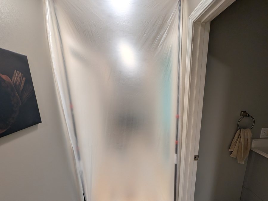 Plastic dust barrier sealing off a doorway during a flooring job