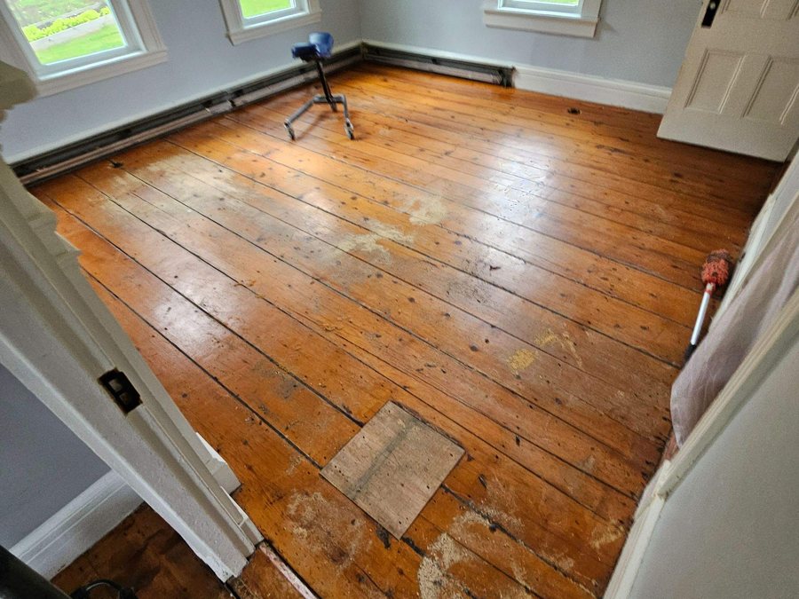 Worn and patched hemlock floor before restoration
